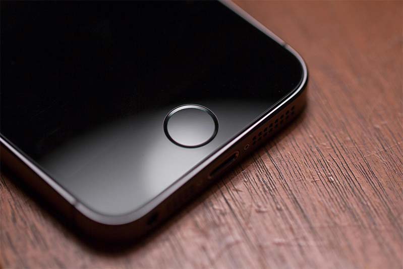 An iPhone 5s home button, which includes a fingerprint scanner.