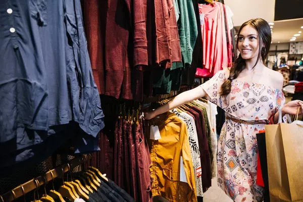 Shopper exploring ready-to-wear clothing in a store
