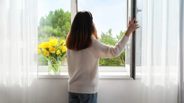 Woman enjoying fresh air through open windows